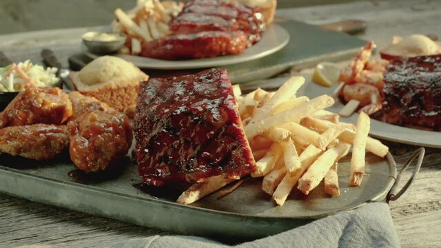 Ribs and Chicken Drumsticks near French Fries on a Rustic Antique Platter