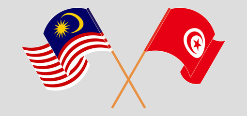 Crossed and waving flags of Malaysia and Tunisia