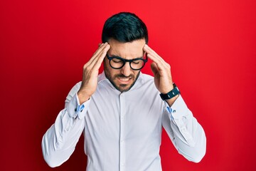 Young hispanic businessman wearing shirt and glasses with hand on head for pain in head because stress. suffering migraine.