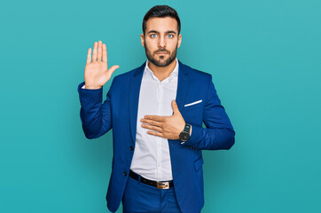 Young hispanic man wearing business jacket swearing with hand on chest and open palm, making a loyalty promise oath - obrazy, fototapety, plakaty