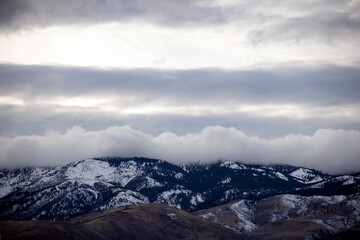 Obraz na płótnie Canvas Dark moody clouds hug blue mountains above C hill in Carson City
