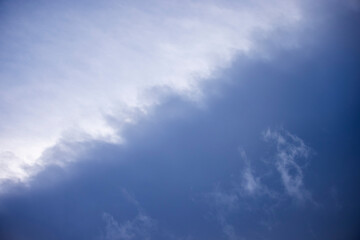 Fototapeta premium Blue white and grey gradient clouds in a softly lit sky