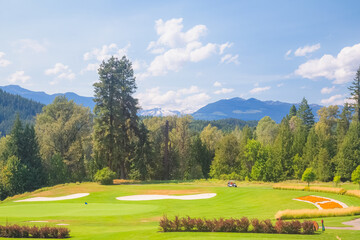 A summer day at Kokanee Springs Golf Resort golf course with view of Selkirk Mountains in Crawford...
