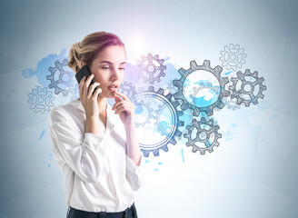 Businesswoman calling on the phone, gears sketch on blue background