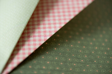folded green and pink scrapbooking paper photographed using a macro lens, featuring a shallow depth of field