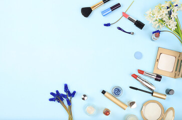 Cosmetics and spring muscari flowers on light background, Creative feminine summer beauty concept, cosmetic salon advertisement with place for text, flat lay composition with powder, lipstick, shadows