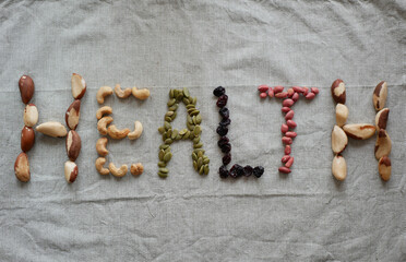 The inscription "health" made with Brazil nuts, cashews, pumpkin seeds, raisins and peanuts