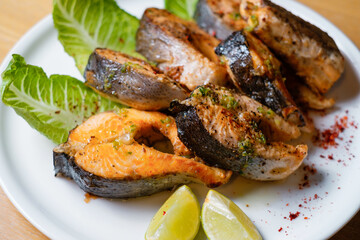 Baked fish with herbs and lemon. Seafood on white plate top view.