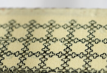 Naklejka premium simple blackwork embroidery on pale yellow even-weave cloth on a white background - book-covers