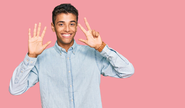 Young handsome african american man wearing casual clothes showing and pointing up with fingers number eight while smiling confident and happy.