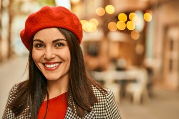 Young hispanic woman smiling happy standing at the city.