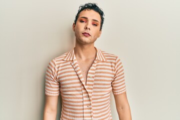 Handsome man wearing make up wearing casual t shirt relaxed with serious expression on face. simple...