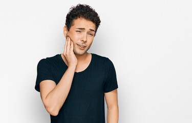 Fototapeta na wymiar Young handsome man wearing casual black t shirt touching mouth with hand with painful expression because of toothache or dental illness on teeth. dentist