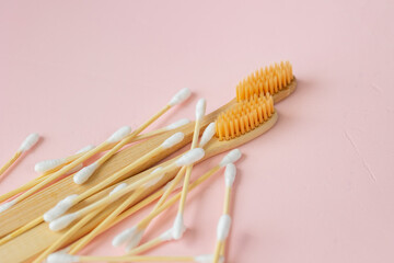 environmentally friendly bamboo and cotton cotton buds on a pink background, bamboo toothbrushes for adults and children. human personal hygiene products without harming the environment, biodegradable