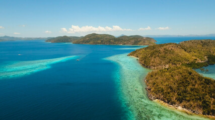 Aerial view: Lagoon with blue, azure water in the middle of small islands and rocks, Palawan. Beach, tropical island, sea bay and lagoon, mountains with forest, Coron. Busuanga. Seascape, tropical