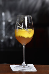refreshing alcoholic drink with berries, ice vodka and gin, lemon peel served in glass cup on the counter on blurred background