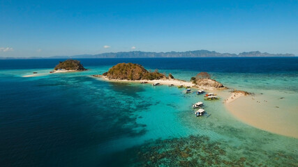 Fototapeta premium Aerial view of tropical beach on the island, Philippines. Beautiful tropical island with sand beach, palm trees. Tropical landscape: beach with palm trees. Seascape: Ocean, sky, sea. 4K video.