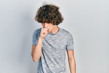 Handsome young man wearing casual grey t shirt feeling unwell and coughing as symptom for cold or...