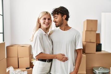 Young beautiful couple smiling happy and hugging at new home.