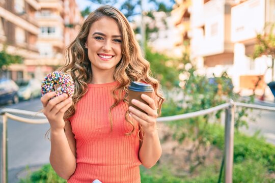 Young blonde girl smiling happy having breakfast at the city.