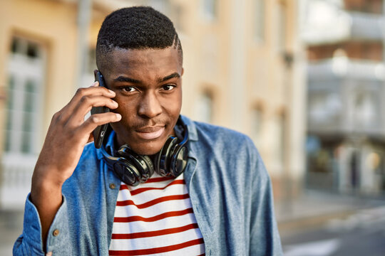 Young african american man with serious expression talking on the smartphone at the city.