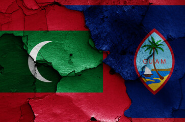 flags of Maldives and Guam painted on cracked wall