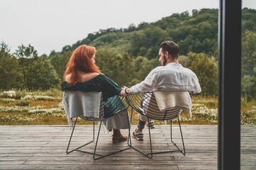 Back view of young family travelers sitting on the terrace 