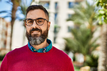 Young hispanic executive man smiling happy standing at the city.