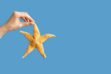 Natural starfish in hands of woman, summer vacation, beach relax concept. Bright summer background