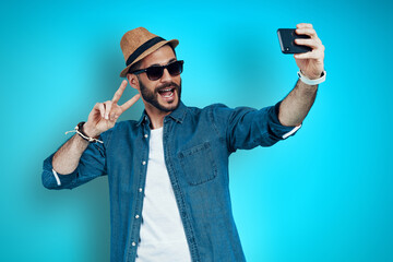 Playful young man smiling and taking selfie 
