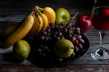 Baroque, renaissance still life fruits on a wooden rustic table with a glass of wine on the side...