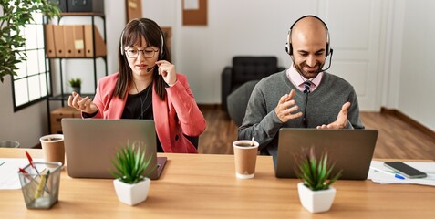 Two call center agent smiling happy having video call using laptop at the office.