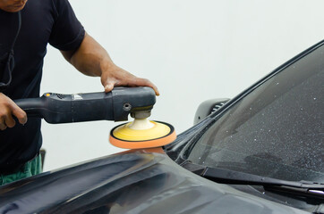 Car detailing - Man working on polishing and caring the exterior with wax. Auto polishing with machine.