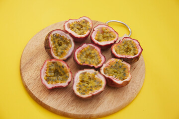 Top view of chopped purple passion fruit and a knife on a wooden board
