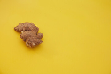 A closeup shot of a ginger root on a yellow background
