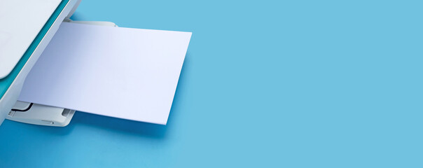 Printer and paper on blue background.