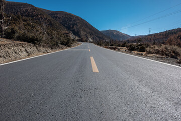 An open road under a snowy mountain
