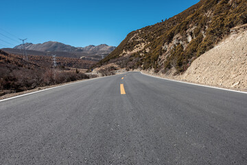 An open road under a snowy mountain