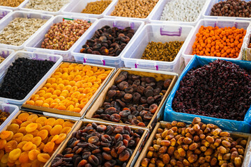 Close-up of beautiful rows of fresh nuts:  figs, raisins, dried apricots. Various nuts on the market showcase