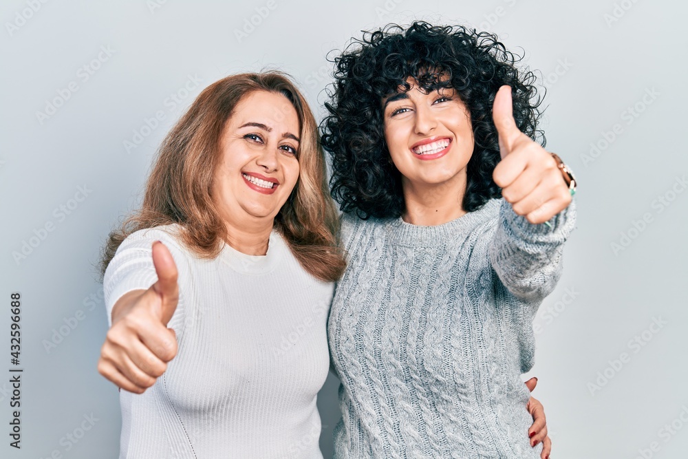 Sticker middle east mother and daughter wearing casual clothes approving doing positive gesture with hand, t