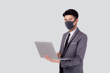 Young asian business man in face mask using laptop computer isolated on white background, quarantine and epidemic covid-19, businessman work from home for health, social distancing, new normal.