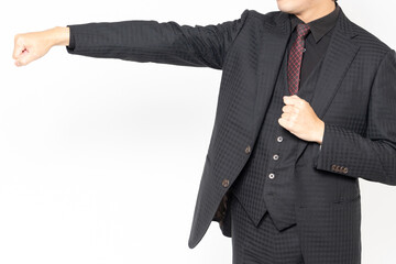 白背景の前に立って、パンチのジェスチャーをする男性ビジネスマン