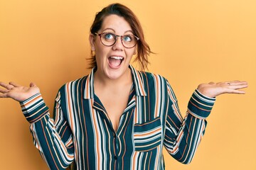 Young caucasian woman wearing casual clothes and glasses celebrating crazy and amazed for success...