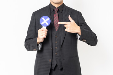 白背景の前に立って、NGのプラカードを持っている男性ビジネスマン