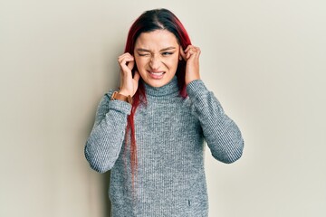 Young caucasian woman wearing casual clothes covering ears with fingers with annoyed expression for the noise of loud music. deaf concept.