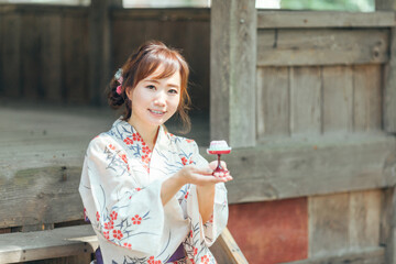 お盆のお供物を持つ浴衣姿の女性
