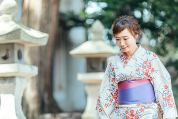 神社を歩く浴衣姿の女性
