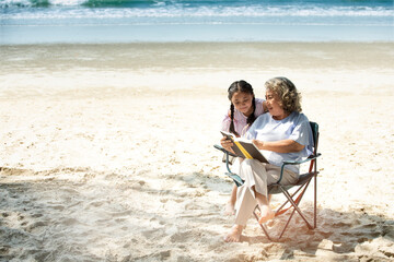 Happy Grandmother with her granddaughter having fun on the beach- Family lifestyle and love concept