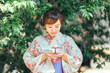 お供物を持つ浴衣姿の女性
