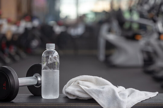 Water bottle and a towel placed on a chair in the gym.